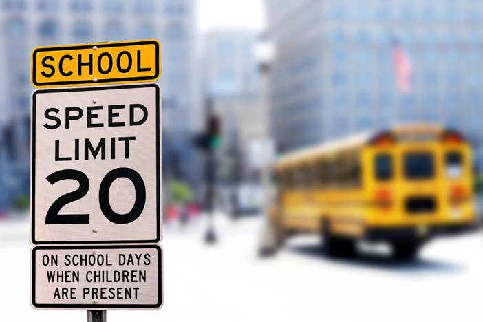 A speed limit sign in front of a school bus
AI-generated content may be incorrect.